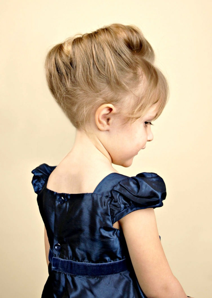 une jolie coiffure médiévale sur la petite fille avec une robe bleue