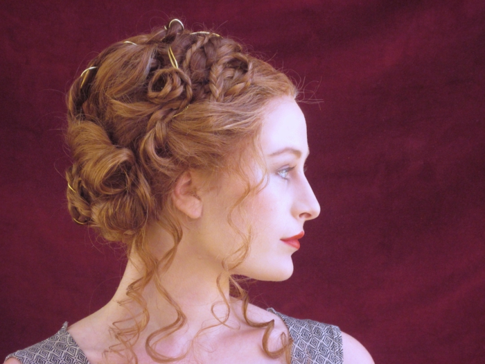 une coiffure de nobles au Moyen Age de cheveux roux, robe grise, rouge à lèvres rose