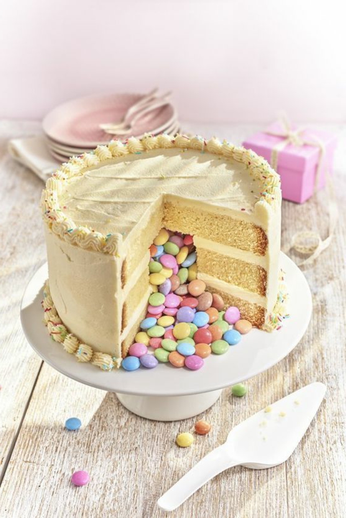 美味的蛋糕充满糖果制成的白色陶瓷蛋糕架