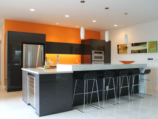 橙厨房墙壁的颜色，吧椅和天花板上的灯