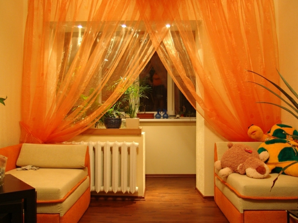 salon avec rideaux transparents en orange - jouets en peluche à côté