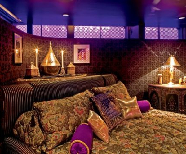 ओरिएंटल बेडरूम के एक elelantes डिजाइन के लिए कई रंगीन फेंक तकिए के साथ मोमबत्तियों और लक्जरी बिस्तर