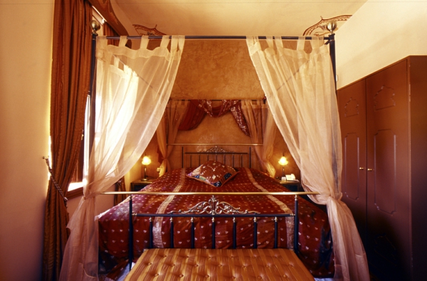 भूरे रंग के रंगों और श्वेत पर्दे के साथ एक उच्चारण-प्राच्य शैली के रूप में बेडरूम