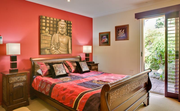 बुद्ध चित्रों के साथ एशियाई बेडरूम के लिए प्राथमिक रंग के रूप में पीची लाल