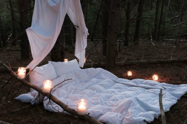 cama al aire libre de moda romántica muchas velas