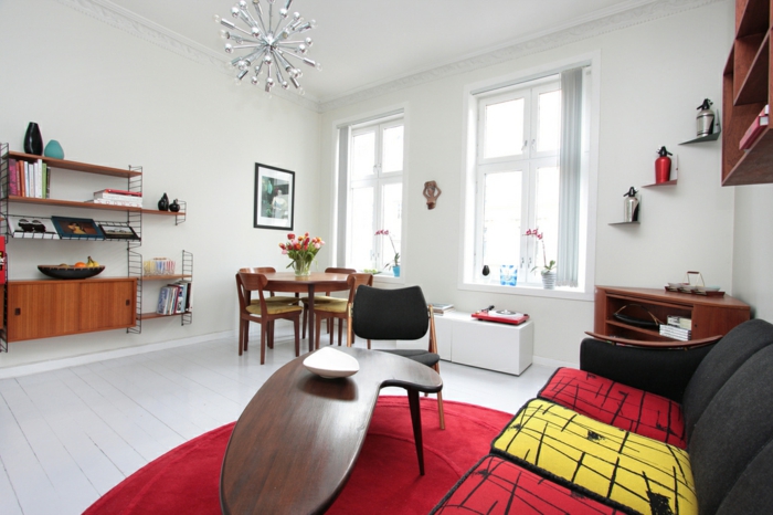 un pequeño apartamento con decoración retro comedor con cuatro sillas, una pequeña mesa inusual, un sofá tapizado