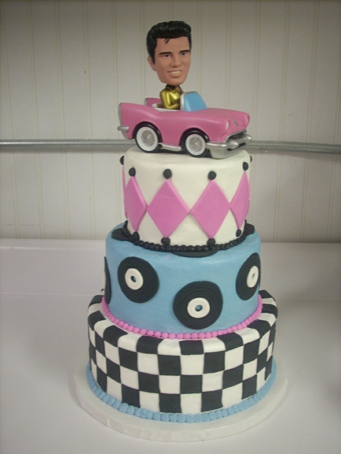 एल्विस एक गुलाबी कार को केक की सजावट के रूप में चलाता है - 50 के दशक के लिए बिल्कुल सही