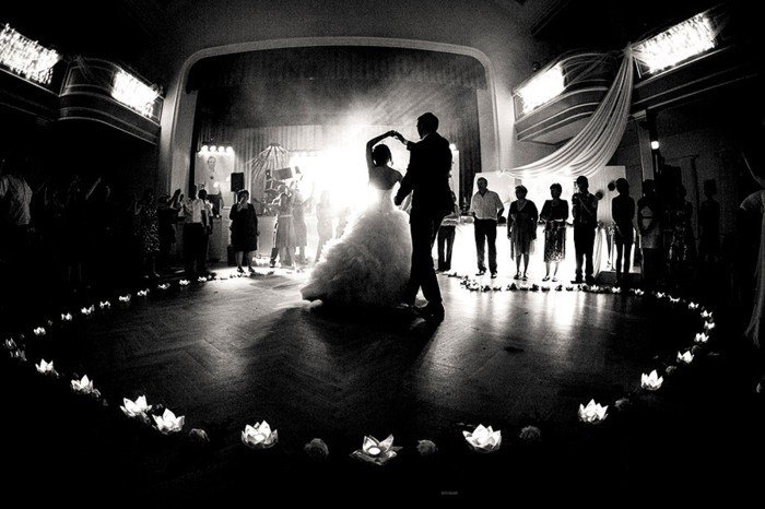 mariage romantique image de-première-danse-conjoints entourées par les invités-bougies fleurs