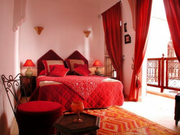 लाल रंग योजनाओं के साथ बेडरूम में बड़े बिस्तर