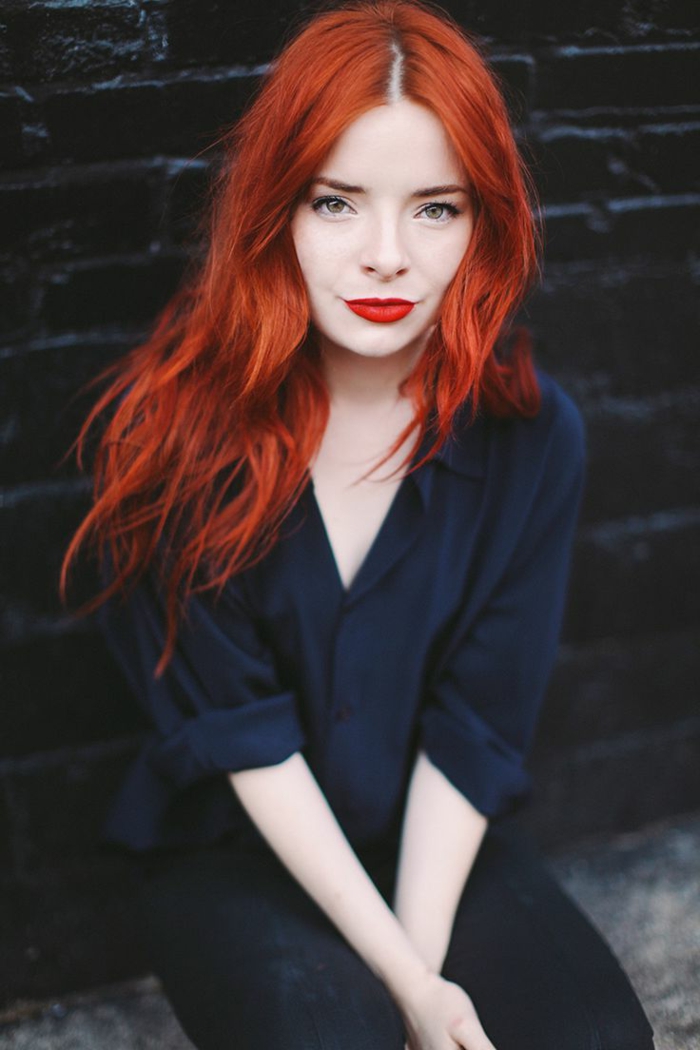 pelo rojo intenso, piel clara, labios rojos brillantes, ojos verdes, ropa casual, camisa azul oscuro