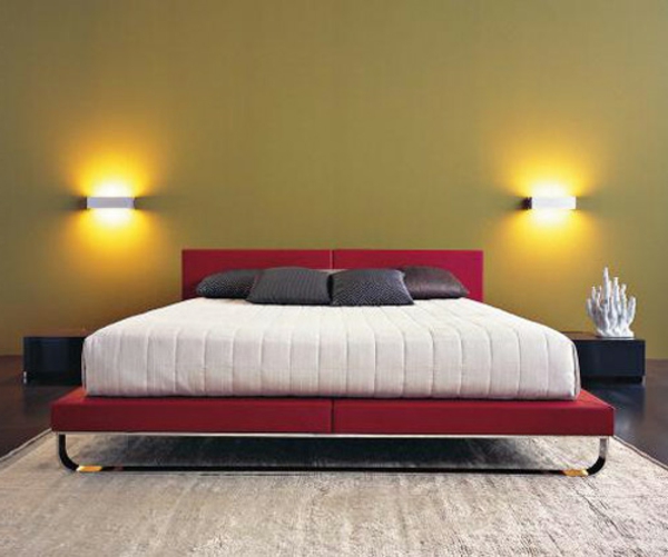 όμορφο κρεβάτι σε κόκκινο και λευκό στο υπνοδωμάτιο με δύο φώτα τοίχου