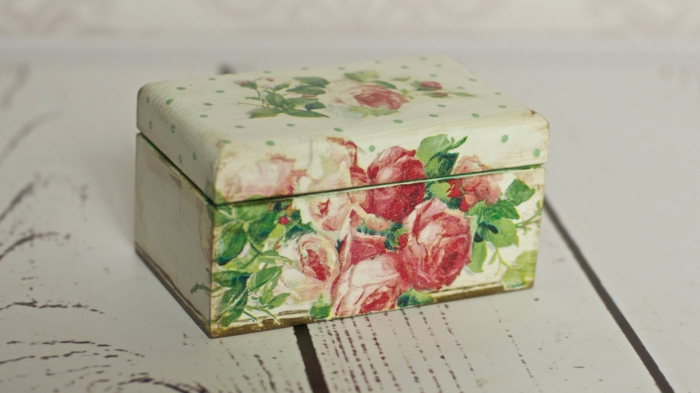 लाल गुलाब के साथ नैपकिन के साथ लकड़ी के बक्से पर नैपकिन