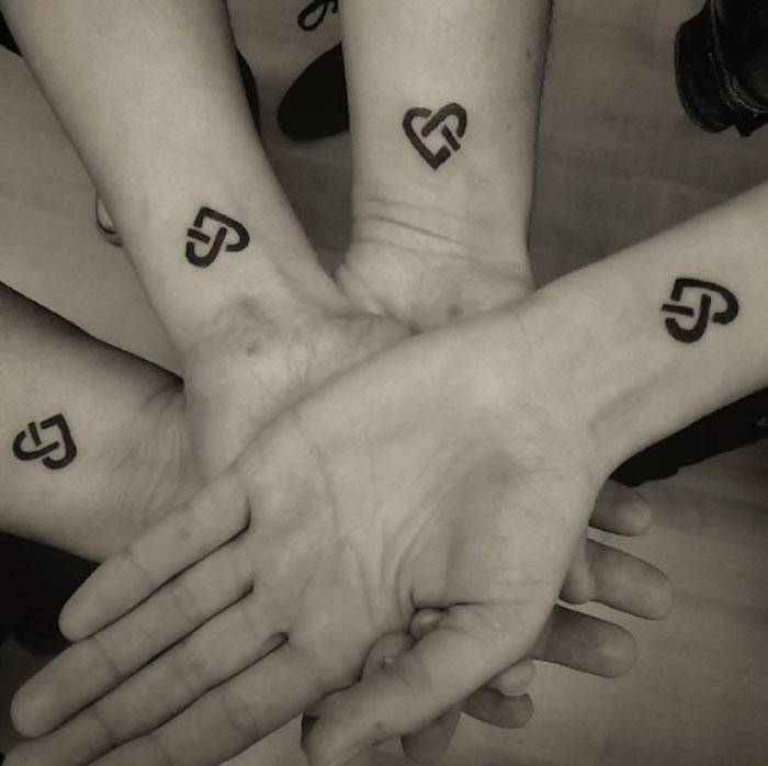 četiri braće s minimalističkim tetoviranim srcem na ručni zglob tetovaže