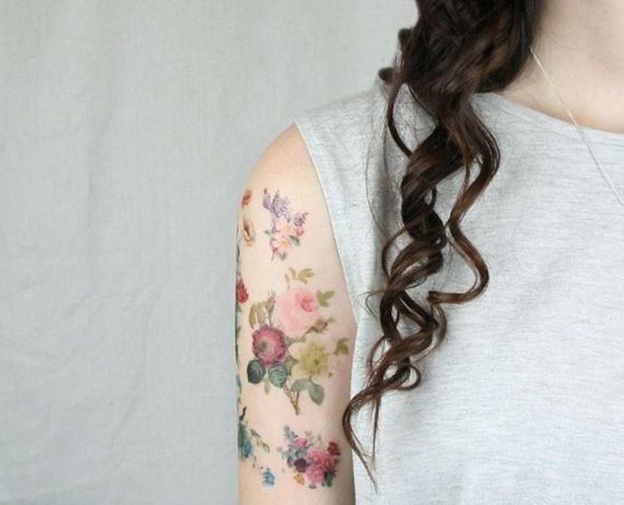 פרחים קטנים, קעקוע צבעוני, קעקוע זרוע, אישה עם שיער מתולתל
