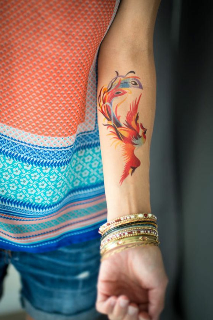 pieni tatuointi ideoita phönih lintu maalattu käsivarteen värikkäillä väreillä monta värikkäitä rannerenkaita