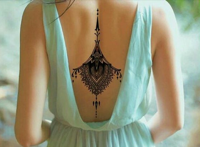 tatuointi motiivi takaisin musta tatuointi koristeltu nainen kaunis sininen mekko avaa takaisin