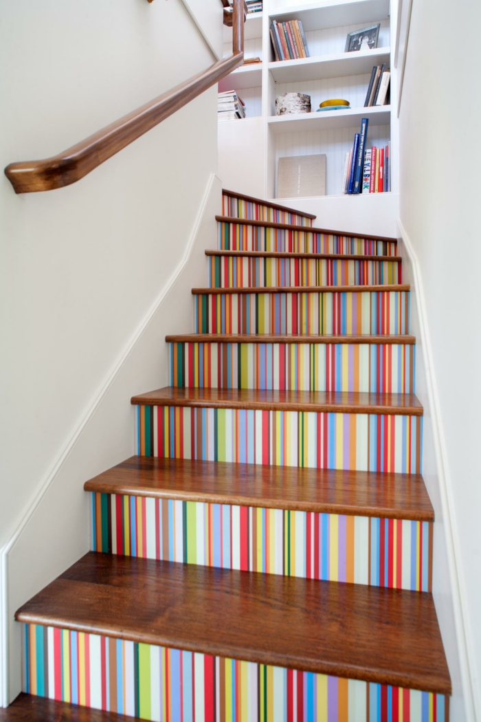 värikkäitä portaita sateenkaaren väreissä kirjahyllyssä - portaikon muotoilu