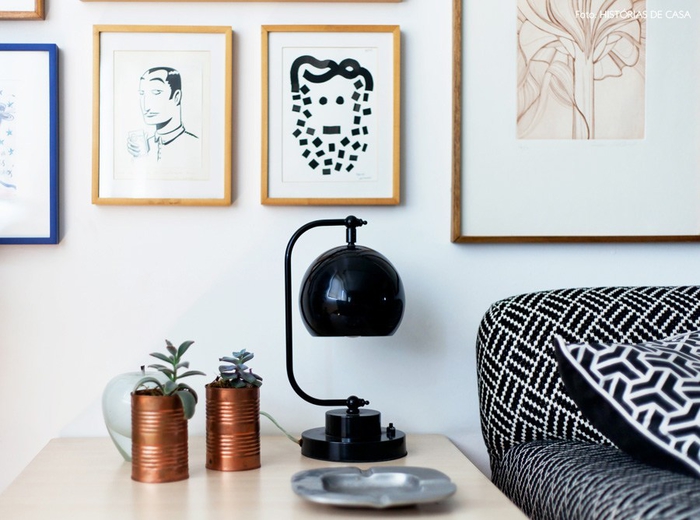 Lampe de chevet vintage en noir, canettes comme pots de fleurs, cendrier, photos sur le mur