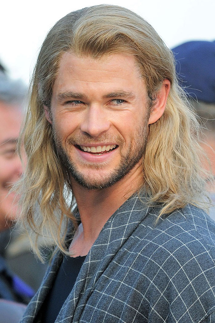 Chris Hemsworth avec de longs cheveux blonds et une barbe noire lors d'un événement