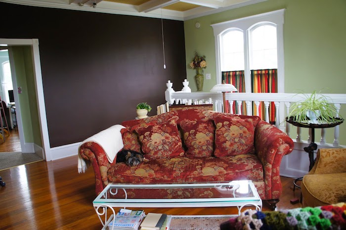 колоритен диван с цветен шаблон и стена в черна дъска в хола