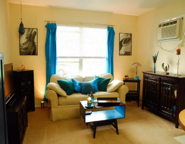 कमरे में रहने वाले डिजाइन-नीले पर्दे और थ्रो-तकिया
