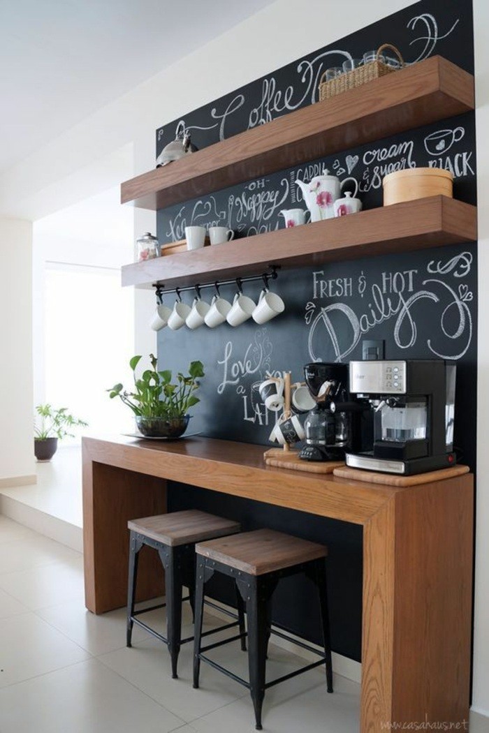wohnungdeko-musta-paneeli-puinen-pöytä-tuolit-kasvi-kahvi-laatat-hyllyt-paidat